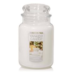 the yankee candle is white and has a glass jar on it that says yankee candle