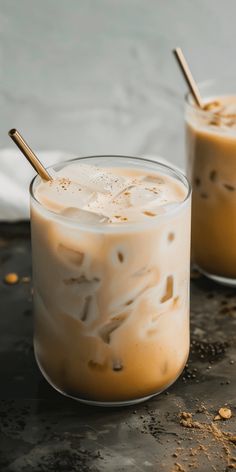 two glasses filled with iced coffee on top of a table