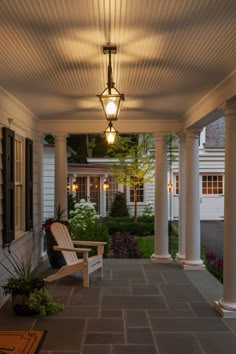 a porch with a bench and lamp on it