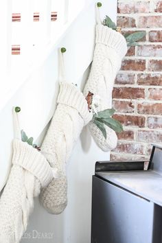 two white socks hanging from the side of a brick wall