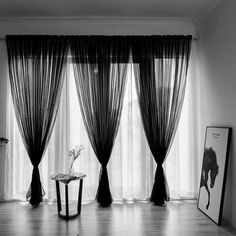 a black and white photo of curtains in a living room