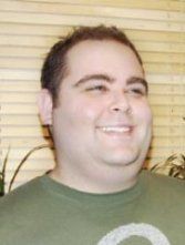 a man in a green shirt smiling at the camera