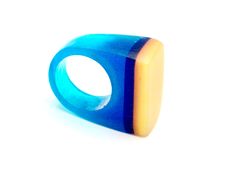 a blue and yellow ring sitting on top of a white surface