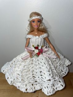 a doll dressed in a white crocheted dress