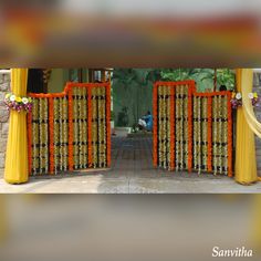 an entrance decorated with orange and yellow decorations for a wedding or reception at the same time