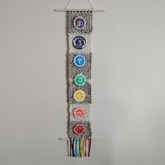 a wall hanging made out of different colored buttons