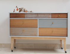 a wooden dresser with drawers and wheels in a room