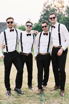 a group of men standing next to each other on top of a grass covered field