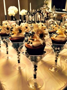 cupcakes with white and black frosting in wine goblets on a table