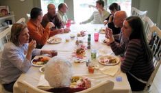 a group of people sitting around a table eating food