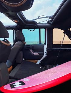 the interior of a vehicle with a pink surfboard