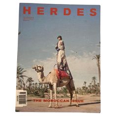 a magazine cover with a woman standing on top of a camel in the middle of the desert