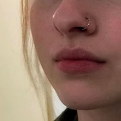 a close up of a person with a nose ring on their nose and piercing in the middle