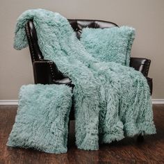 a chair with two pillows and a blanket on it