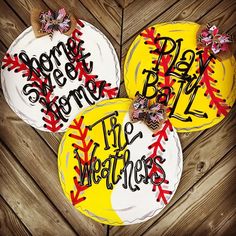 three decorated cakes with words on them sitting on top of a wooden table next to each other