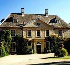 a large house with many windows and lots of greenery