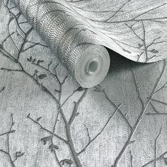 a roll of silver foil sitting on top of a tree branch covered in leaves and branches