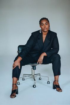 a woman sitting on top of a black chair