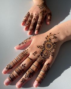 two hands with henna tattoos on them