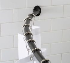 a metal chain is attached to a white brick wall