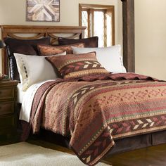 a bed covered in a brown and white quilt