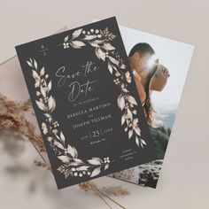 an image of a wedding save the date card on top of a table with dried flowers