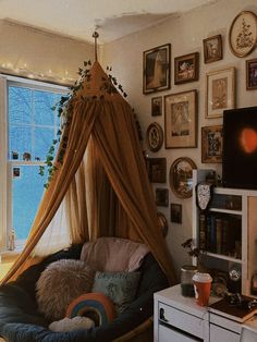 a living room filled with furniture and lots of pictures on the wall next to a window