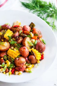 a white bowl filled with corn and potatoes