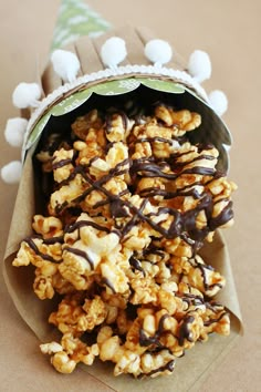 a bag filled with popcorn covered in chocolate and marshmallows