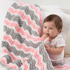 a baby is holding onto a crocheted blanket