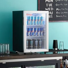 a mini fridge filled with drinks on top of a counter