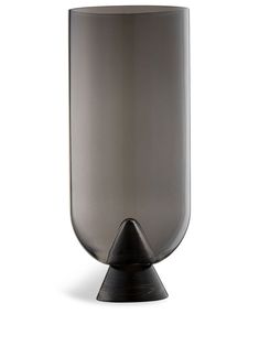 a black vase sitting on top of a white table next to a metal cone shaped object