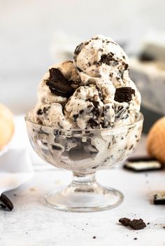 an ice cream sundae with cookies and oreo chips in a glass bowl on a table