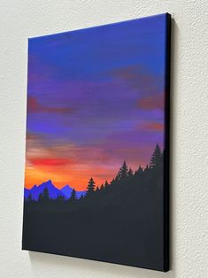 a painting on the wall of a house with trees and mountains in the background at sunset