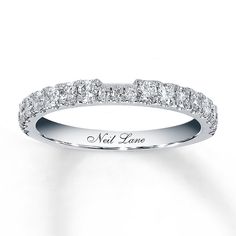 a white gold wedding band with diamonds on the sides and words that read, not love