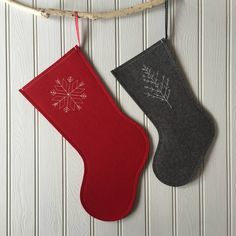 two christmas stockings hanging from a rope with snowflakes on the top and bottom