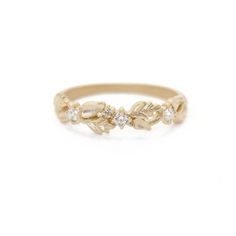 a gold ring with leaves and diamonds on the side, in front of a white background