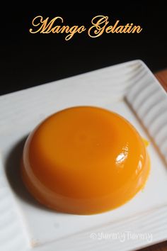 an orange dessert on a white plate with the words mango gelatin