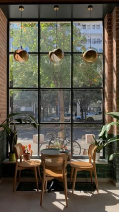 two chairs and a table in front of a window with large panes on it