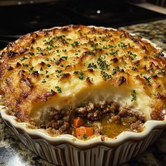 a casserole dish with meat and vegetables in it on a kitchen counter top