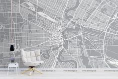 a white chair sitting in front of a wall with a large city map on it