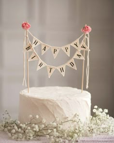 a white cake topped with a happy birthday banner