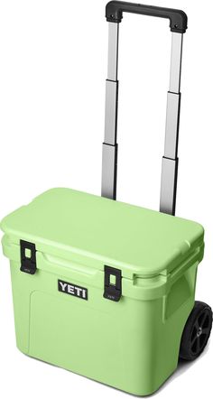 the yeti wheeled cooler is light green with black handles and two wheels on each side