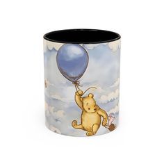 a winnie the pooh mug with a blue balloon on it's handle and an image of a pig flying in the sky