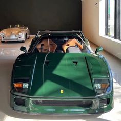 two green sports cars parked in a garage