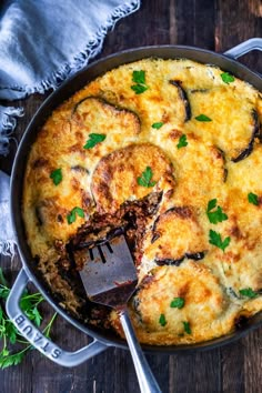 an omelet with cheese and parsley in a skillet on a wooden table