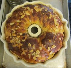 a bundt cake sitting on top of a pan covered in nuts and raisins