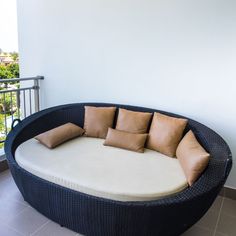 a round couch with pillows on top of it