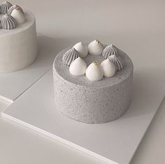 two cakes with white frosting and seashells on top