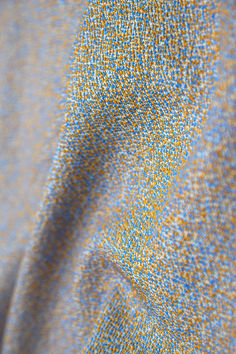 an up close shot of a blue and yellow speckled fabric